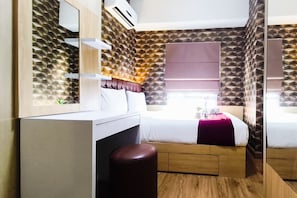 Una moderna camera d'albergo con un originale motivo geometrico sulla parete, un letto con poggiatesta, un comodino e uno specchio.