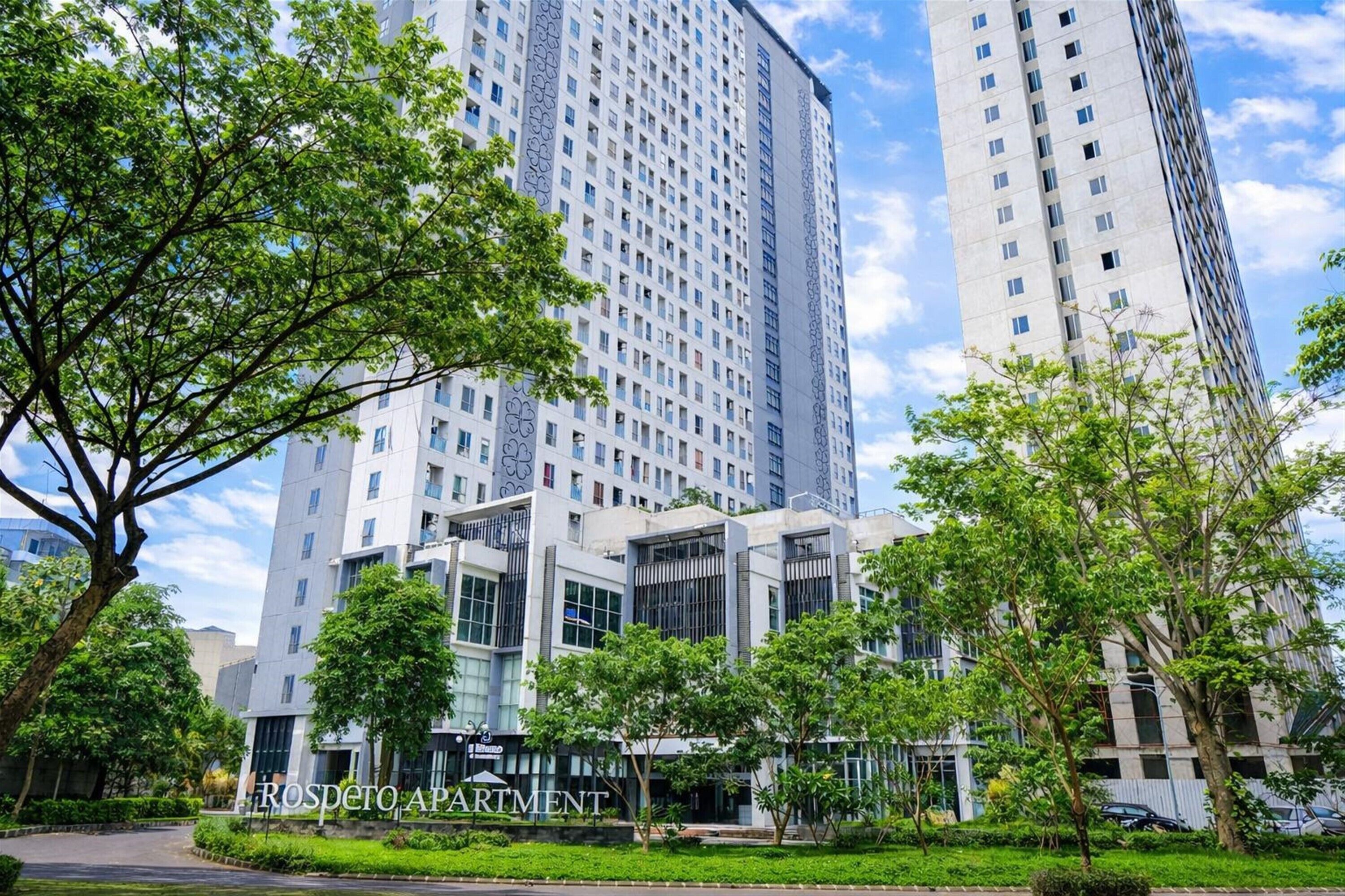 Un moderno edificio de apartamentos con un cartel que dice 'ROSPETO APARTMENT'.