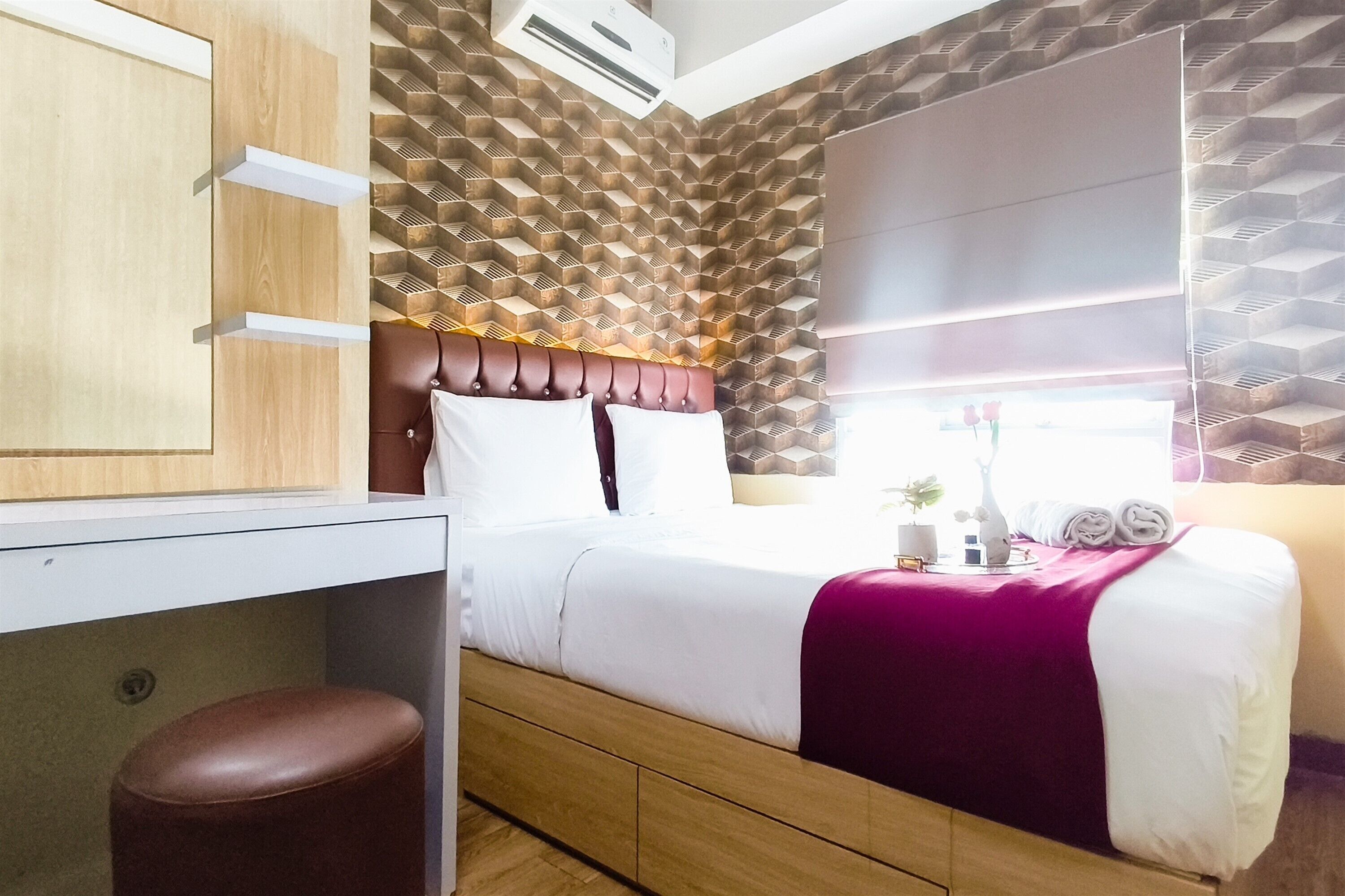 Una habitación de hotel compacta con cama, escritorio y armario.