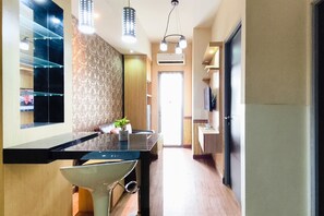 Una cucina moderna con piano di lavoro nero, elettrodomestici in acciaio inossidabile e illuminazione a sospensione.