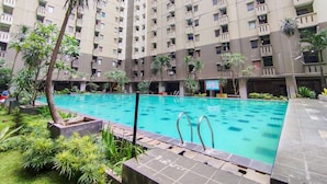 A residential building with multiple balconies and a swimming pool. - Comfortable 2Br At Apartment Gateway Ahmad Yani Cicadas (Bandung)