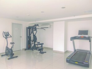 Ein Fitnessraum mit Laufband, Crosstrainer und Kraftmaschine.