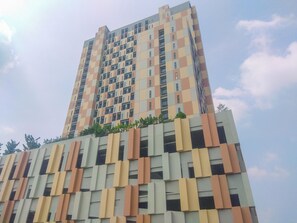Ein mehrgeschossiges Gebäude mit einer strukturierten Fassade und Balkonen.