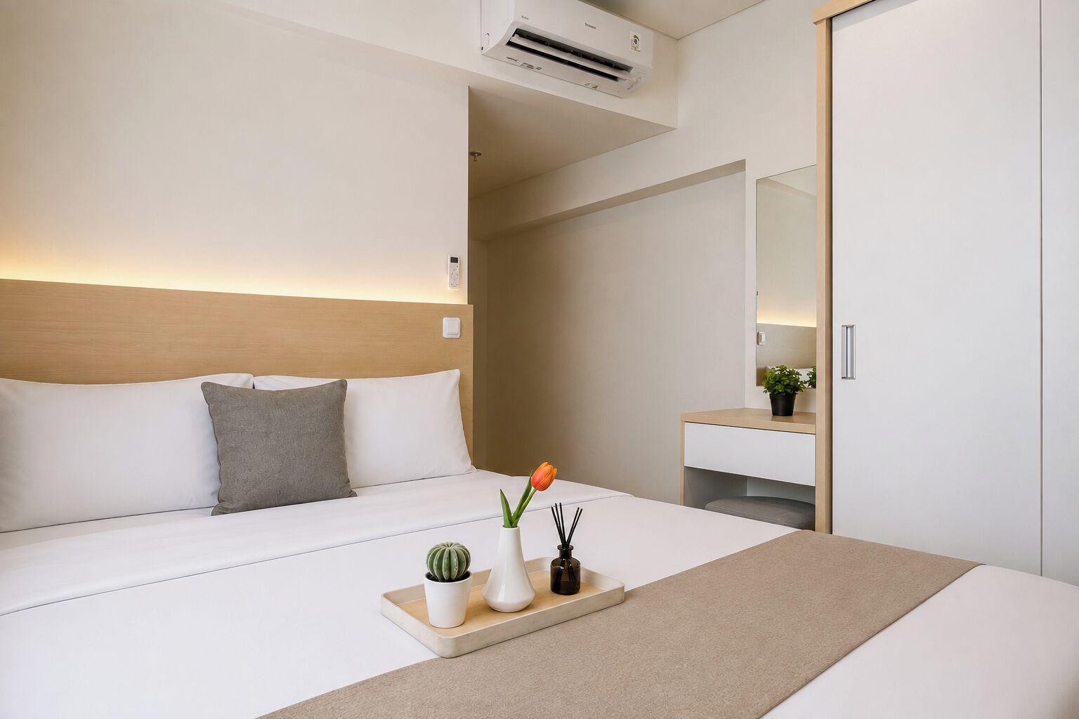 Une chambre d’hôtel avec un lit, une table de chevet et un miroir.
