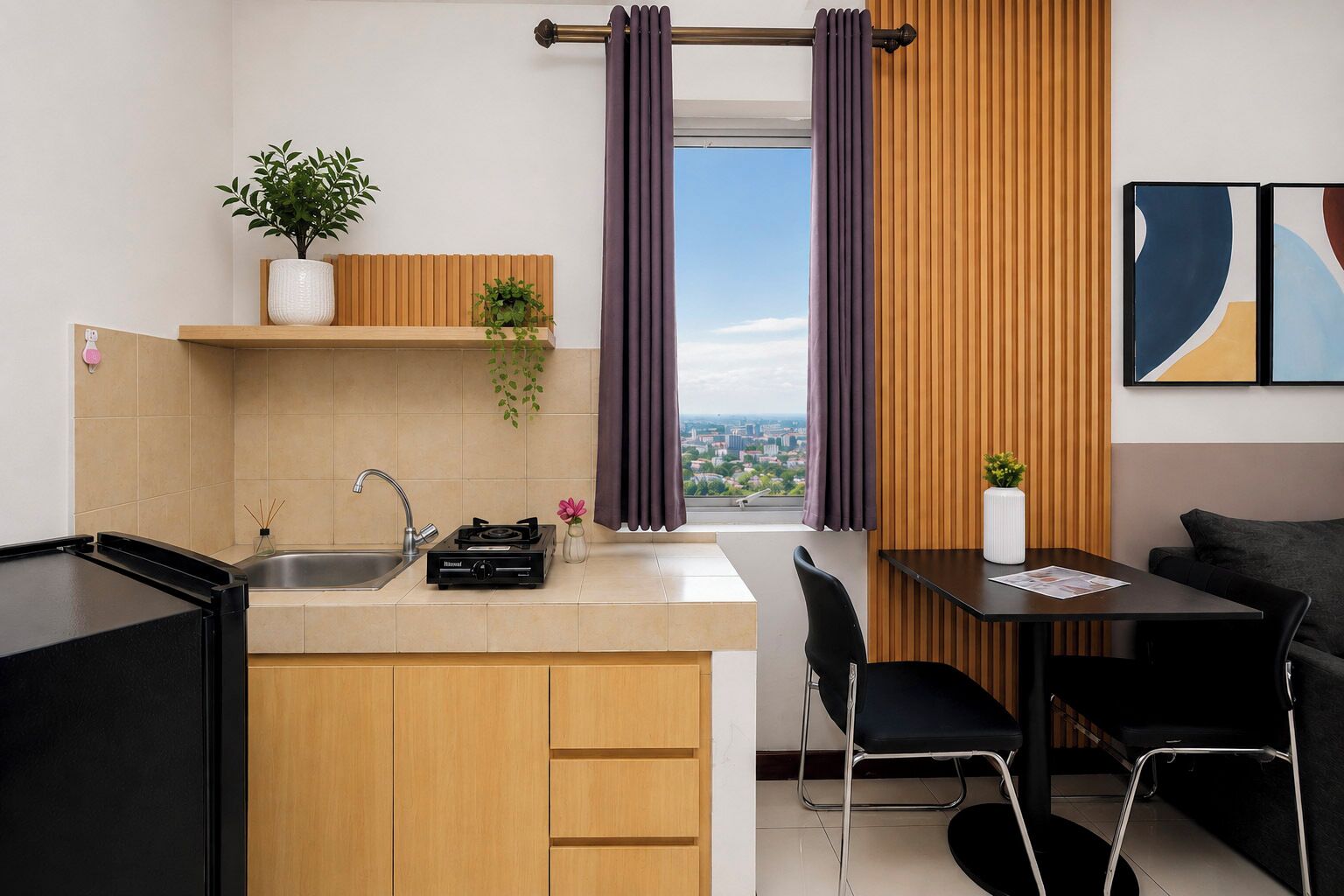 A compact kitchen with a built-in stove, a sink, and a window with curtains.