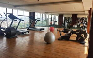 A gym with treadmills, elliptical machines, and exercise balls. - Well Appointed Studio At Apartment The Pinncale (Semarang)