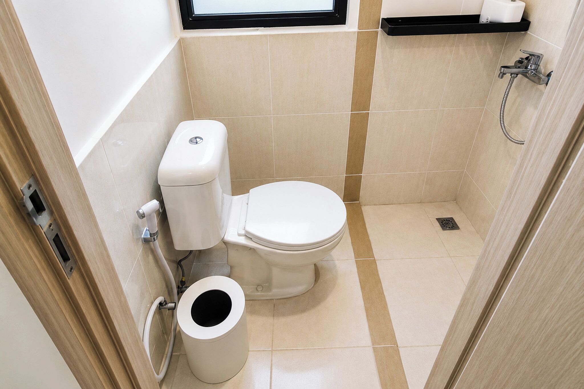 Un baño pequeño con inodoro, bidé y un ventanal.