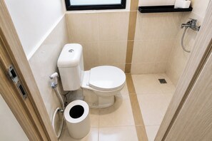 A compact bathroom with a toilet, bidet, and a small window. - Bright And Homey Studio Room At Apartment Meikarta District 1 (Cikarang)
