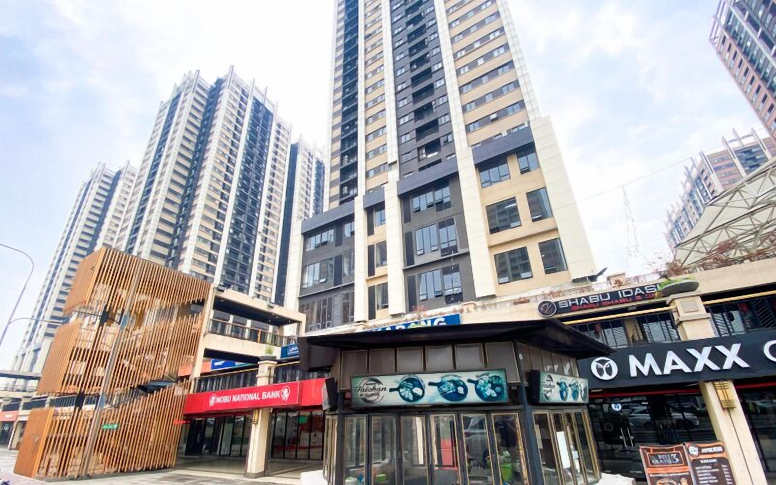 Zona comercial con edificios altos, un banco y diversas tiendas, entre ellas una joyería.