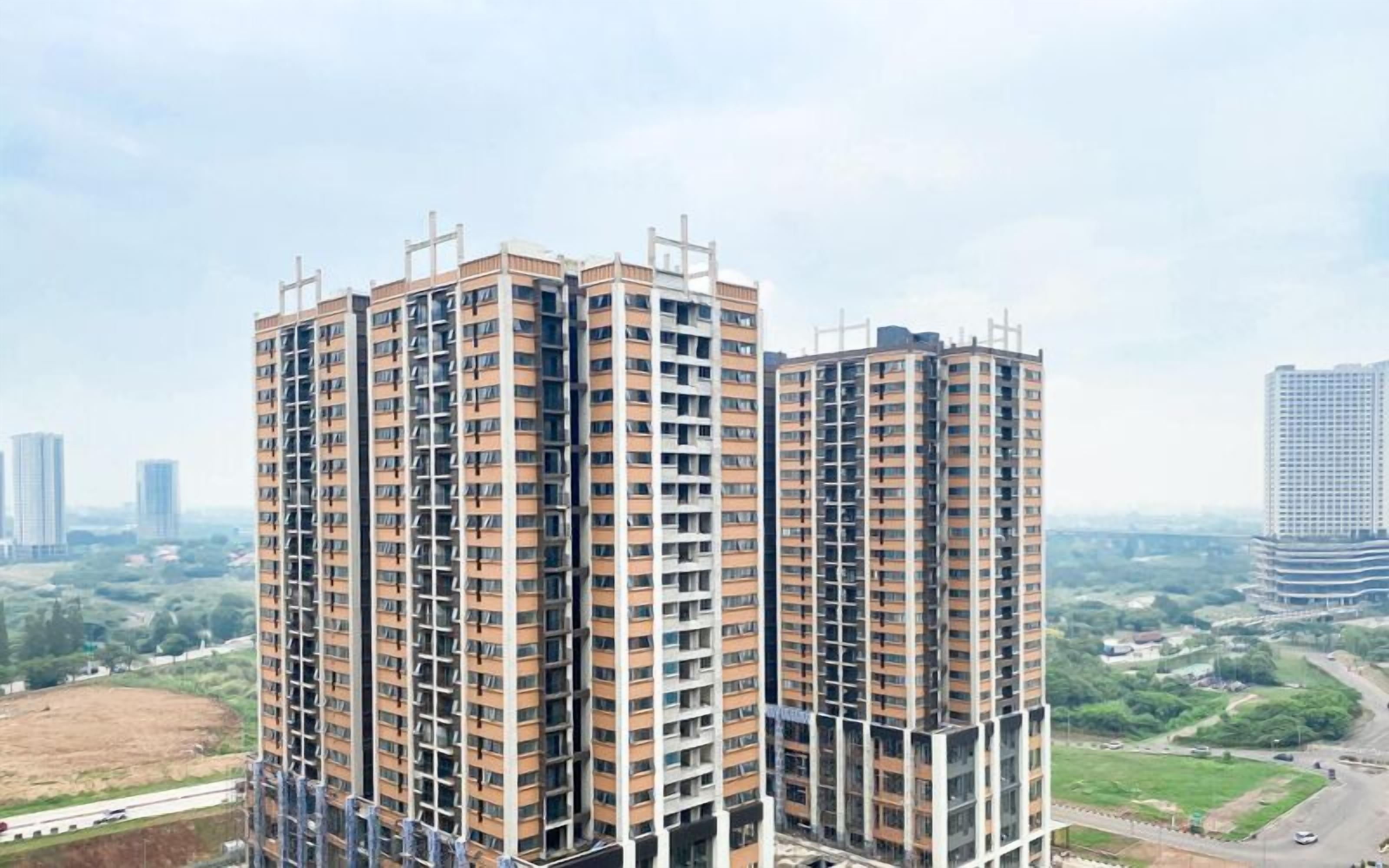 Un edificio residencial de gran altura con múltiples pisos, ventanas amplias y un diseño arquitectónico moderno.