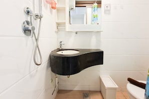 A bathroom with a black sink, a toilet, and a shower. - Functional Homey Studio Room At Apartment Sky House Bsd (Tangerang)