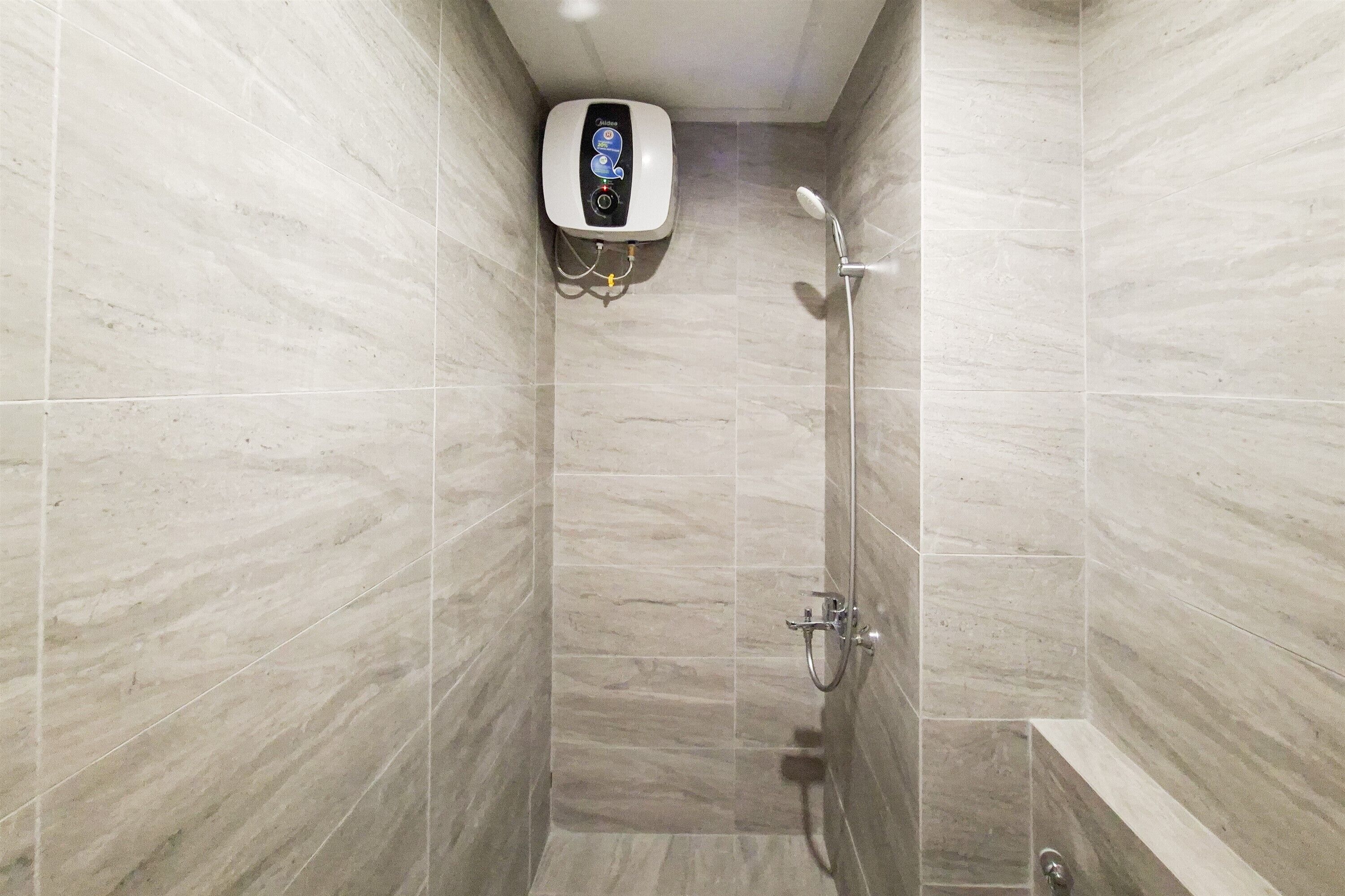 A shower area with a handheld showerhead, a wall-mounted control panel, and a bathtub.