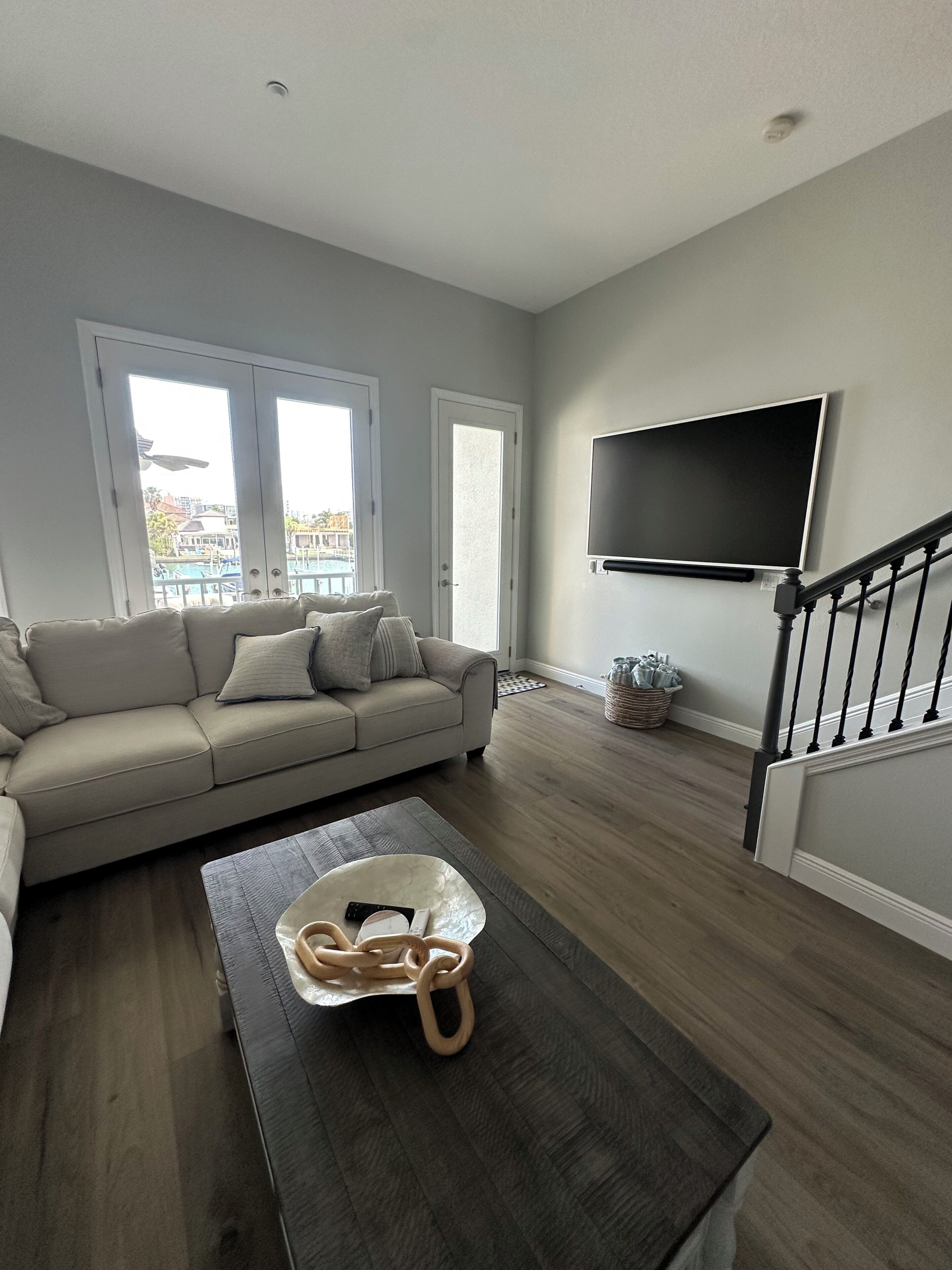 Un salon avec un canapé, une table basse et un téléviseur fixé au mur.