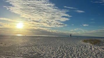 A beach with footprints and a lifeguard tower.