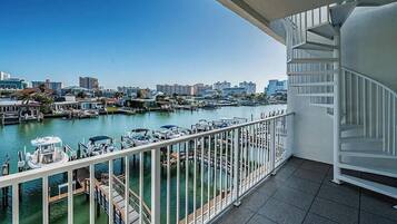 A balcony with a view of a marina and city skyline.