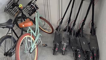 A utility room with electrical panels, pipes, and a bicycle with a basket.