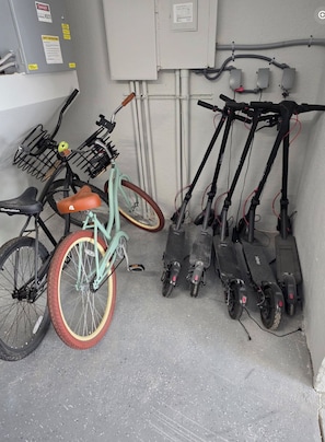 A utility room with electrical panels, pipes, and a bicycle with a basket. - Clearwater Beach Escape (Clearwater)