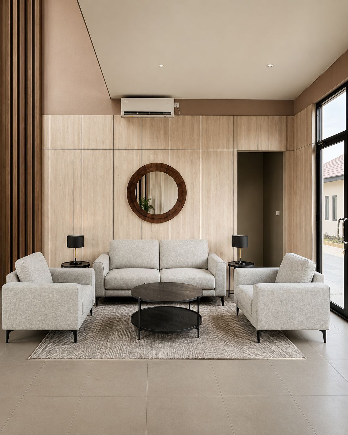 Una sala de estar moderna con un sofá, dos sillones, una mesa de centro y un espejo redondo en la pared.