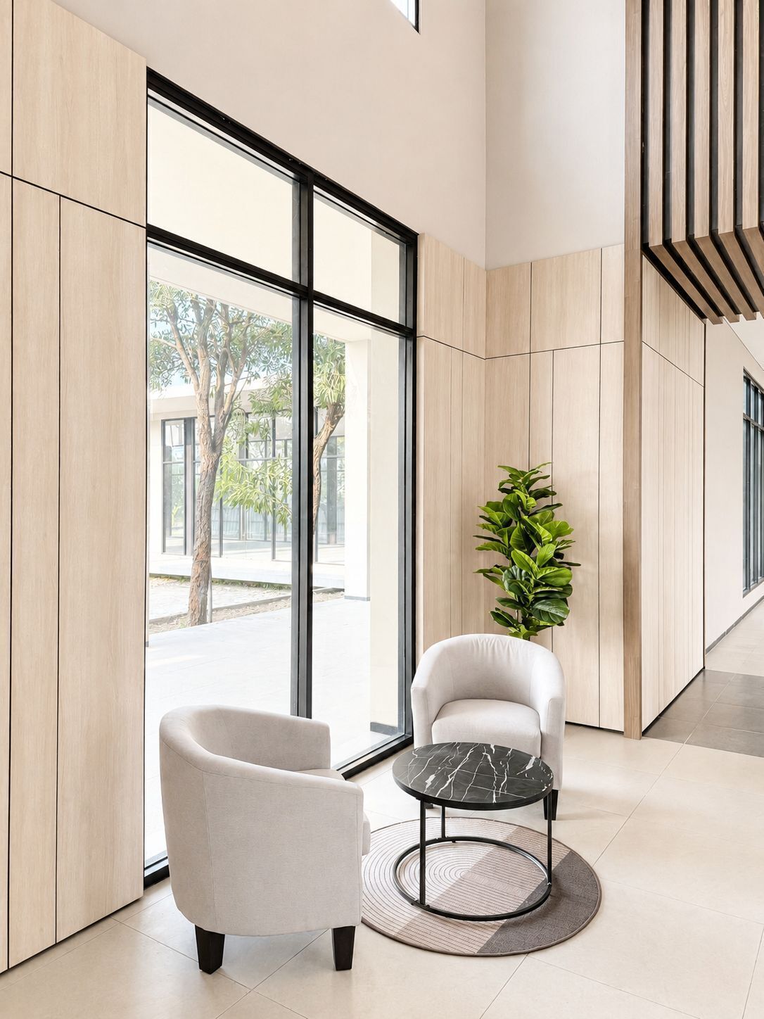 Un interior moderno con un ventanal grande, un sillón blanco, una mesa redonda y una planta en maceta.