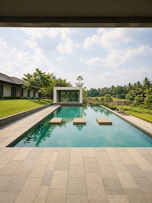 A rectangular swimming pool with clear blue water, surrounded by a paved deck. - Serene Modern 1BR at Sora Villa Cilegon (Cilegon)