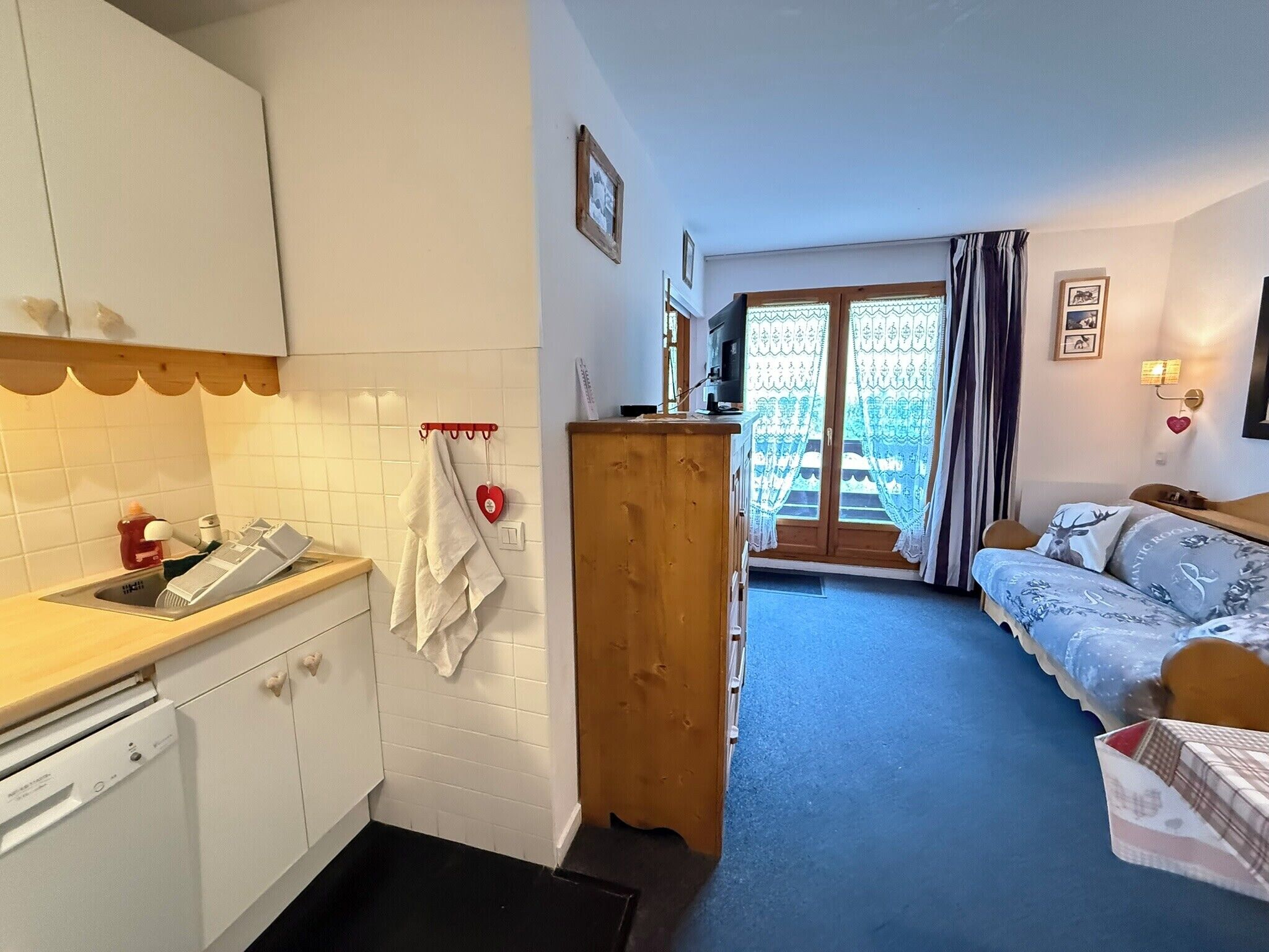 Un espace de vie compact comprenant une kitchenette, un coin repas et une chambre.