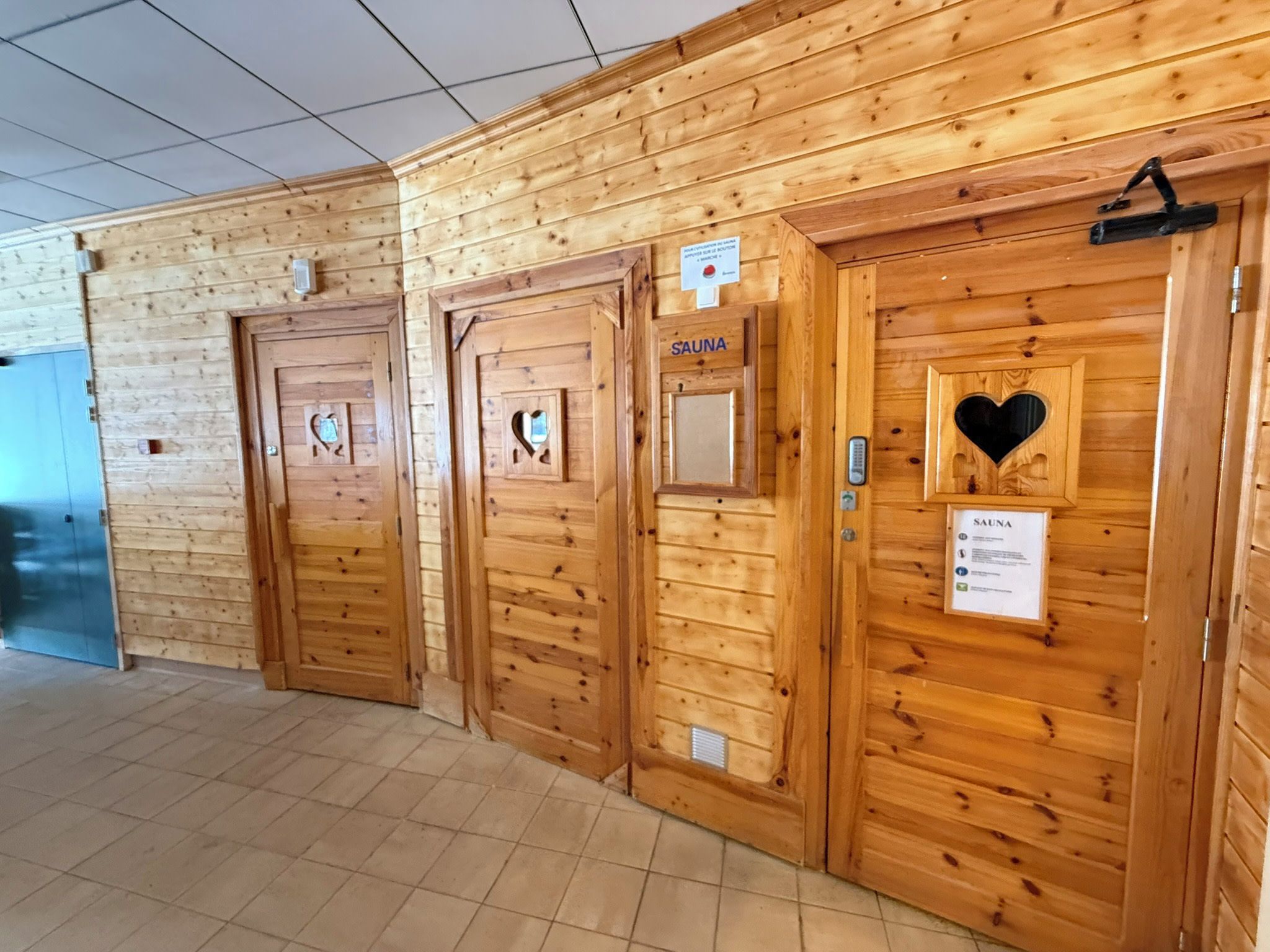 A row of wooden doors with a sign indicating a sauna.