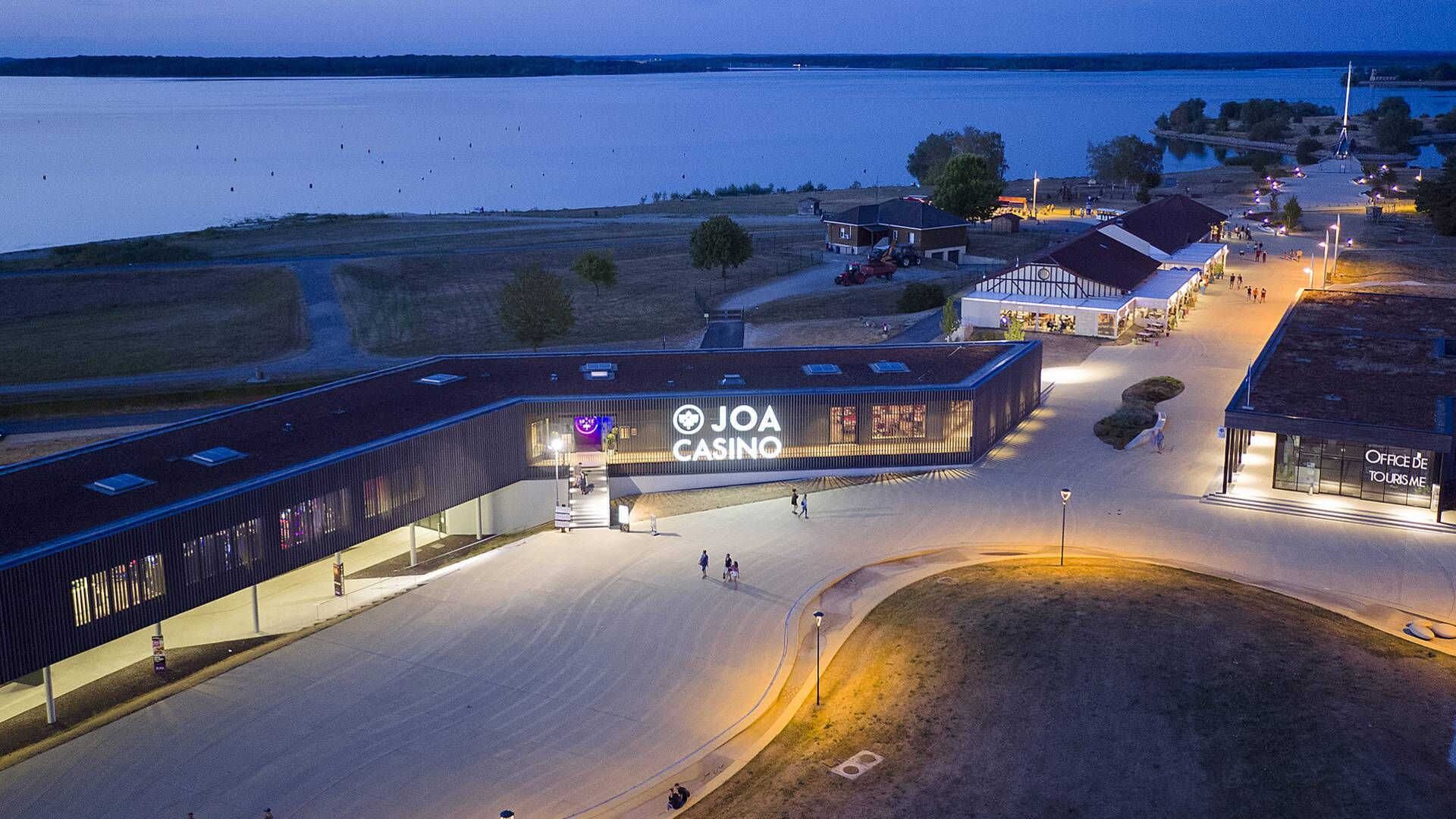 Een casino met een modern design, nabij een waterpartij.