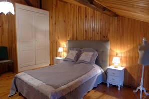 Ein Schlafzimmer mit einem Bett, Nachttischen, einem Kleiderschrank und einer Lampe.
