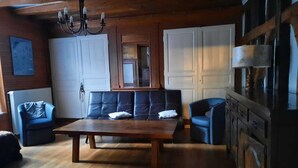 Ett rymligt vardagsrum med ett träbord, soffor och ett köksområde med skåp.
