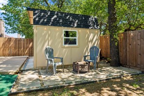 A small outdoor shed with two chairs and a fire pit. - Family Friendly 3-bedroom home in Mansfield For Long Term Living - FTW 25 mins (Mansfield)