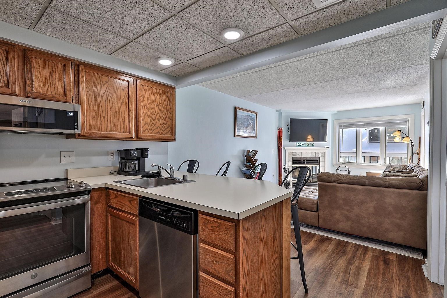 A modern kitchen with wooden cabinets, stainless steel appliances, and a central island.