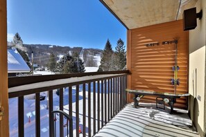 En balkon med udsigt over et sneklædt landskab og en stolelift i baggrunden.