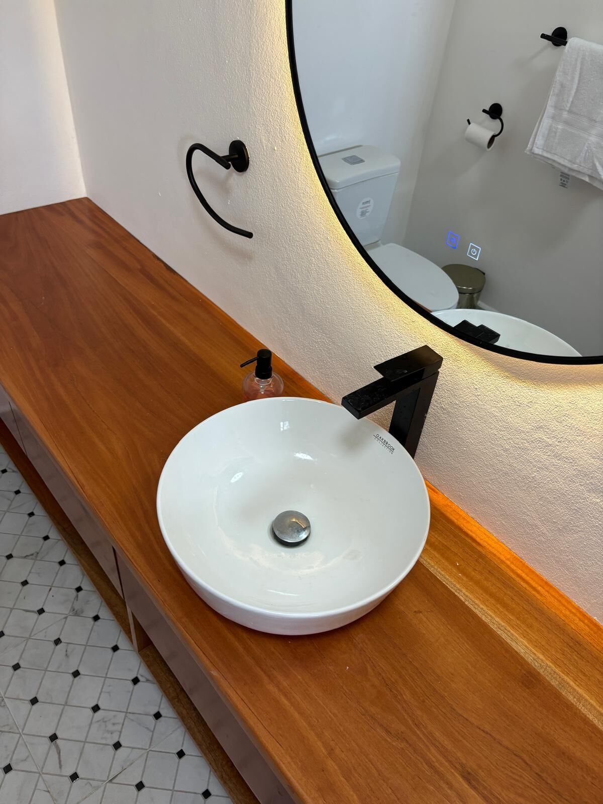 A bathroom with a white sink, a mirror, and a toilet.