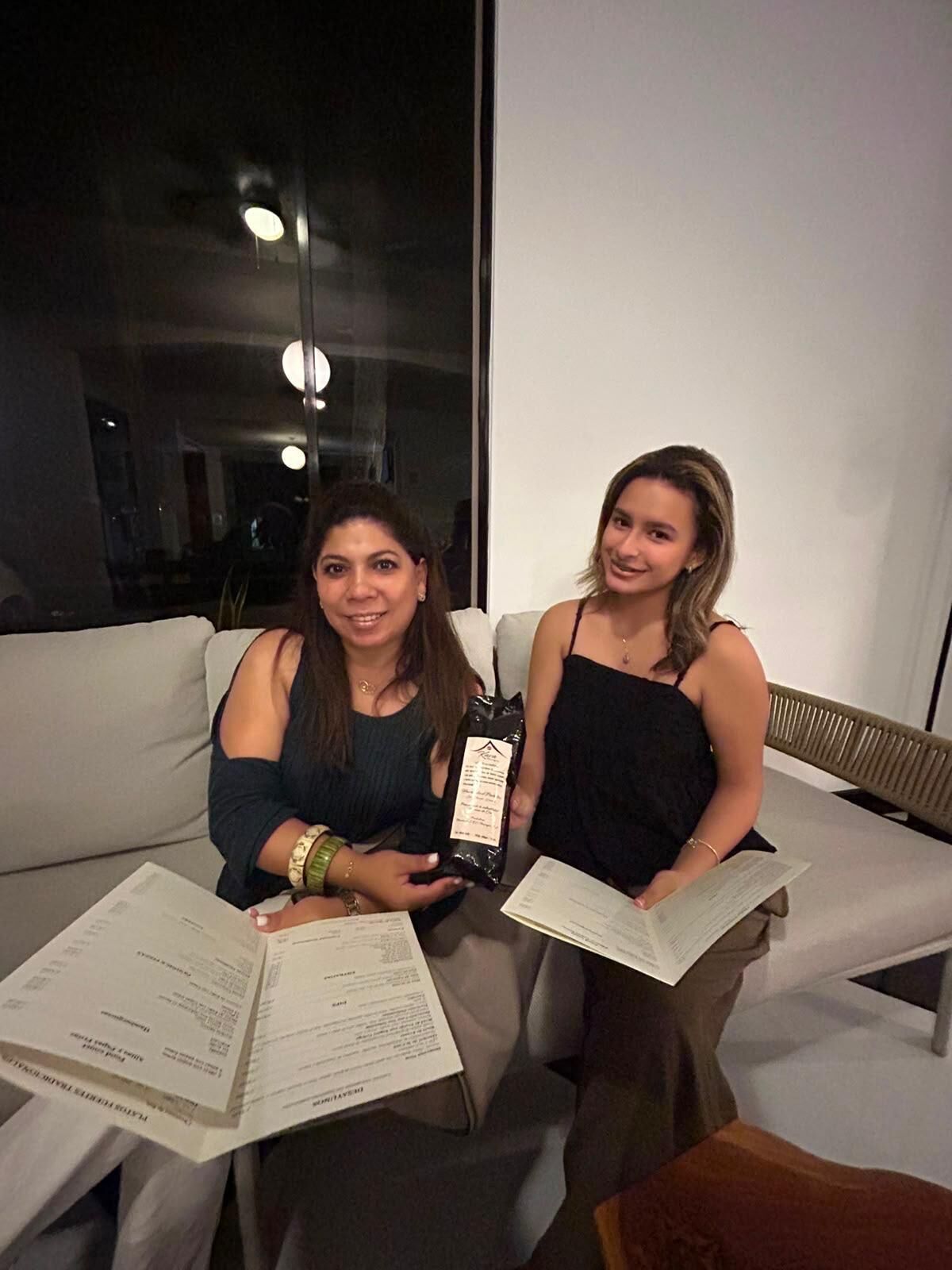 Deux personnes sont assises sur un canapé, devant elles se trouvent des documents et un paquet.