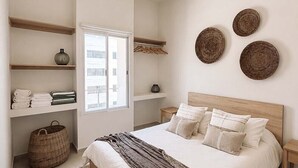 A bedroom with a bed, a ceiling fan, a window, and wall-mounted decor.