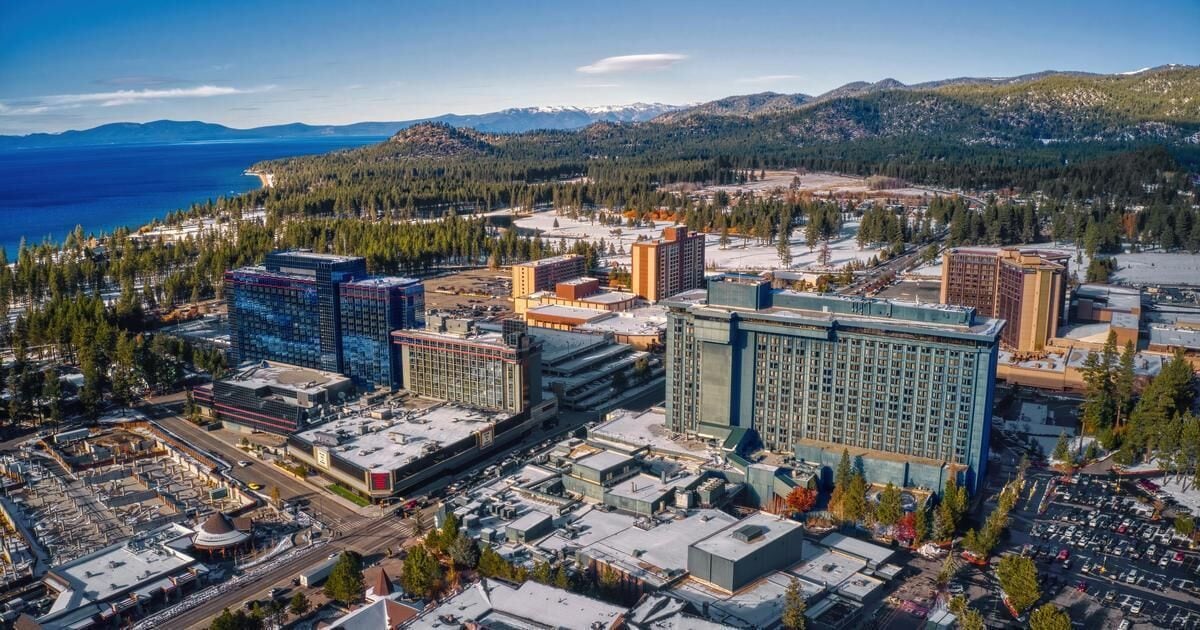 A cityscape with modern buildings, a large hotel, and a mountainous backdrop.
