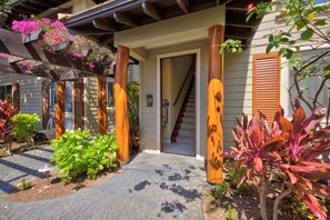 A residential property with a covered porch, a staircase leading to the interior, and a variety of potted plants. - 🌴 Hale Kolepa | AC | Located By Mauna Lani Golf Course 🌴 (Waimea)
