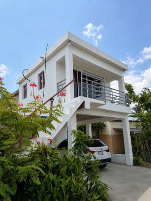 A modern two-story house with a car parked in the driveway.