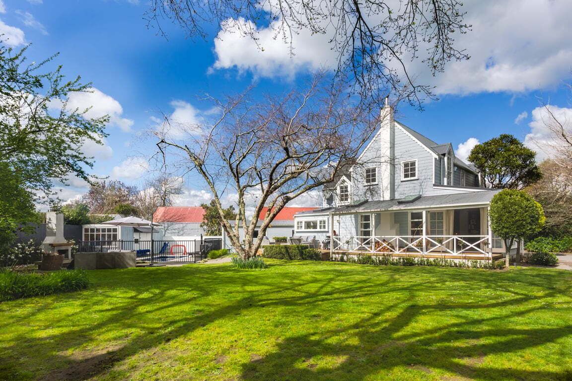 A two-story house with a large front porch and a well-maintained lawn.