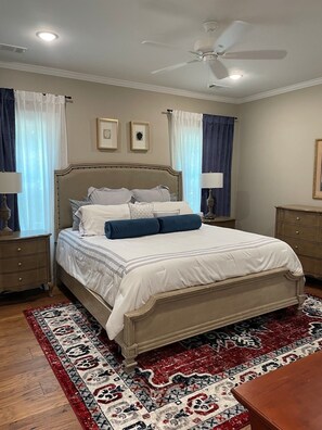 A bedroom with a bed, nightstands, a ceiling fan, and a patterned rug. - 3-Bdrm Oxford Home Away From Home 6 mins to The Square, 3.9 miles to The Stadium (Oxford)