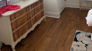 A room with a wooden dresser, a white door, a small bedside table with a lamp, and a patterned rug. - 3-Bdrm Oxford Home Away From Home 6 mins to The Square, 3.9 miles to The Stadium (Oxford)