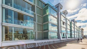 A modern building with large windows, a patterned ground floor, and a clear sky. - Smart Compact Two Bedrooms 2 Bath & Two Balconies (Auckland City)