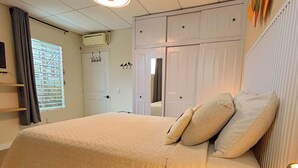 A bedroom with a bed, a desk, a window with curtains, and a ceiling fan. - Charming 1BR Home Near Downtown SS & Metrocentro (San Salvador)