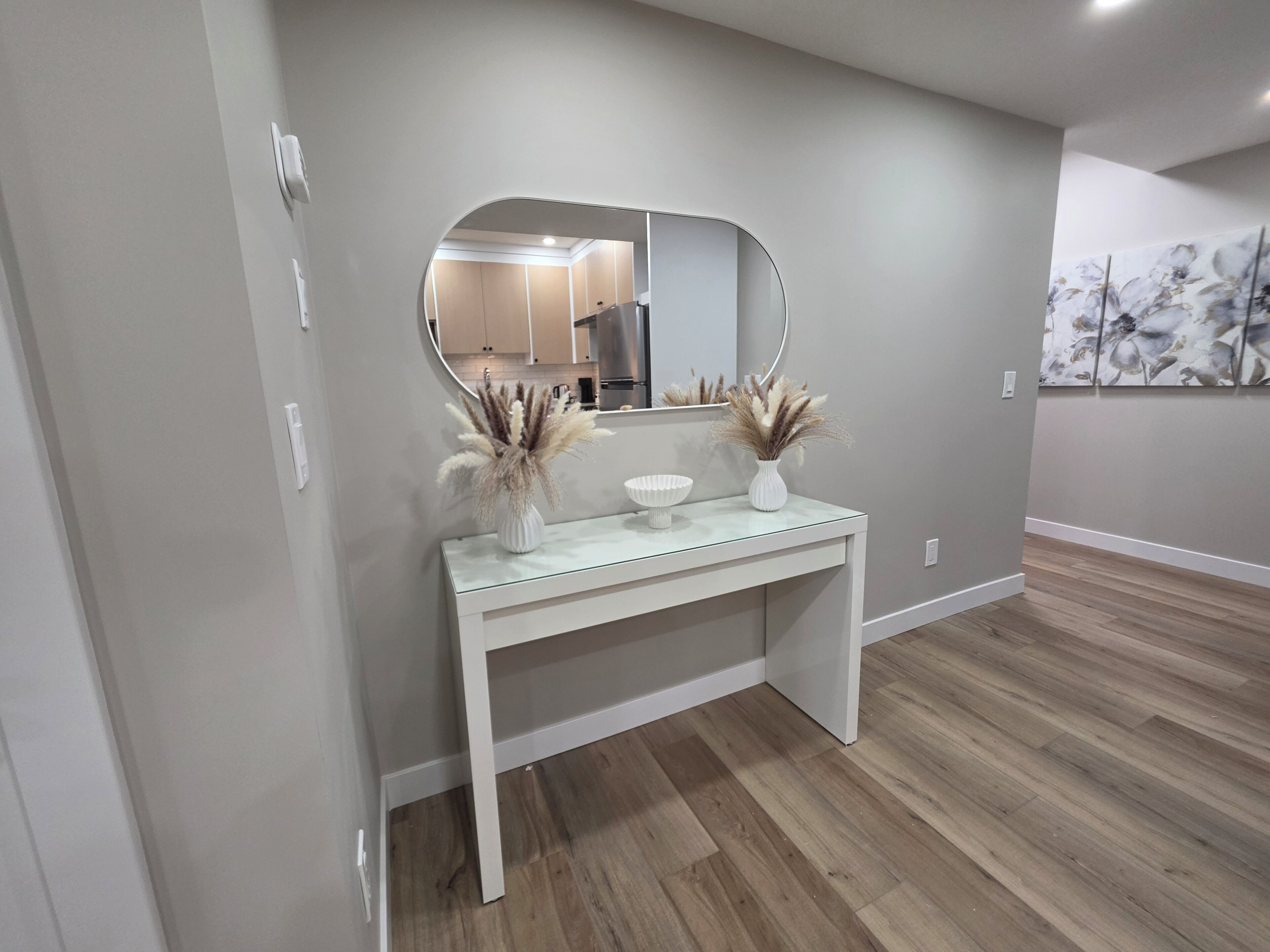 A modern bathroom with a vanity, mirror, and decorative plants.