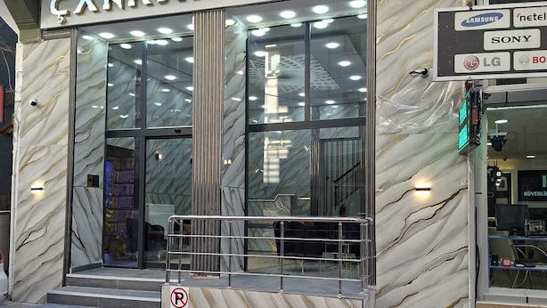 A hotel entrance with a marble facade, glass doors, and a sign indicating no parking.