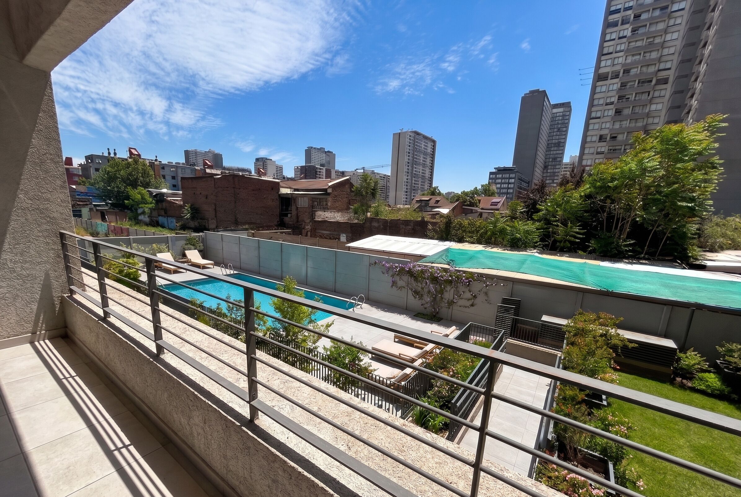 A residential area with a swimming pool, a brick building, and high-rise buildings in the background.