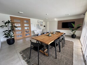 A modern dining area with a wooden table, black chairs, and potted plants. - Eco Estación Santiago by Domus Travels (Santiago)