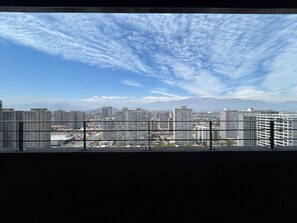 Paisagem urbana com edifícios altos e uma montanha ao longe.
