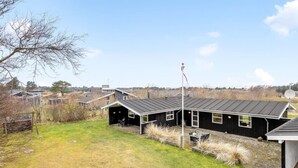 Een modern gebouw met een plat dak, grote ramen en een vlaggenmast.