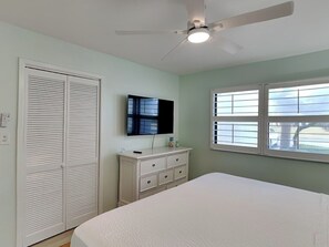 A bedroom with a bed, a dresser, a ceiling fan, a window, and a closet. - Bright, Updated Love's Coastal Villa Retreat w/ Heated Pool & Resort Perks (Panama City Beach)
